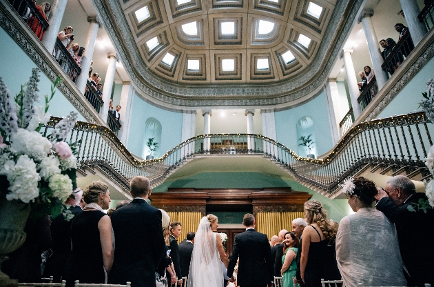 Couple walking down the aisle inside Leigh Court