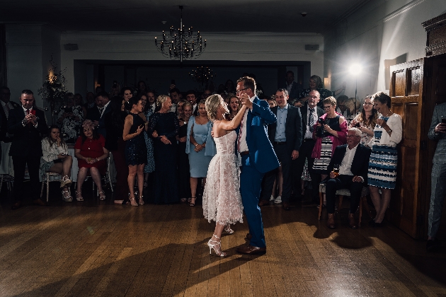 Bride and groom dancing surrounded by their friends and family