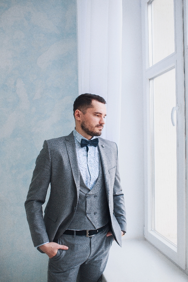 Man wearing a grey suit looking out the window