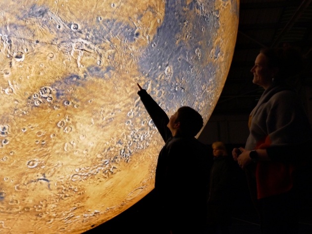 Child pointing at projection of the moon