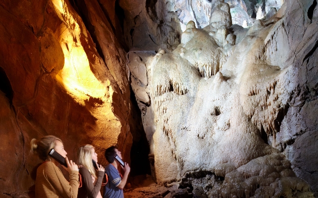 Visitors to Cheddar Gorge listening to audio guide. 