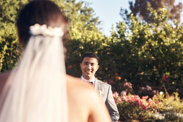 groom looking up an aisle to the bride walking down