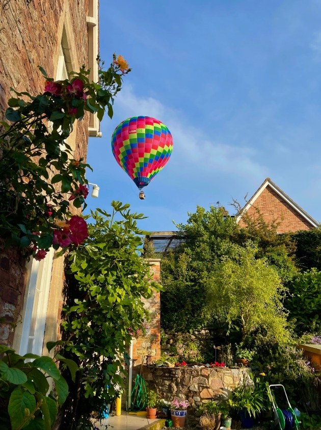 Colourful hot air balloon flying over Bath during the spring