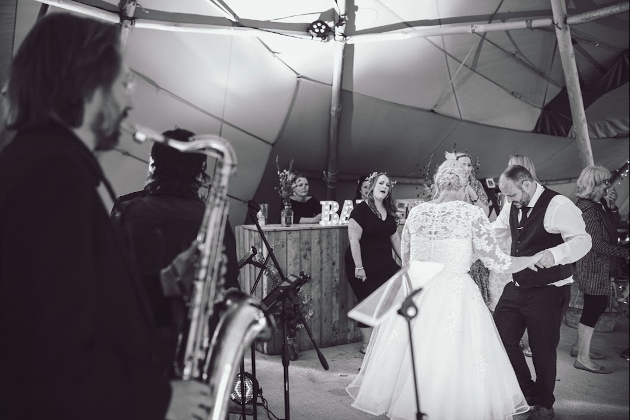 bride and groom dancing at wedding with sax player