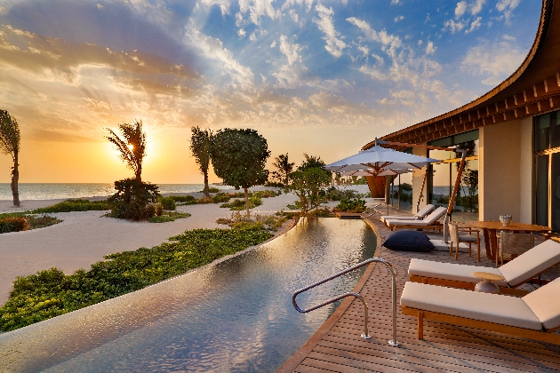 A swimming pool overlooking the sea at sun set