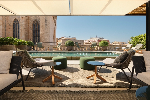 A rooftop swimming pool behind two chairs