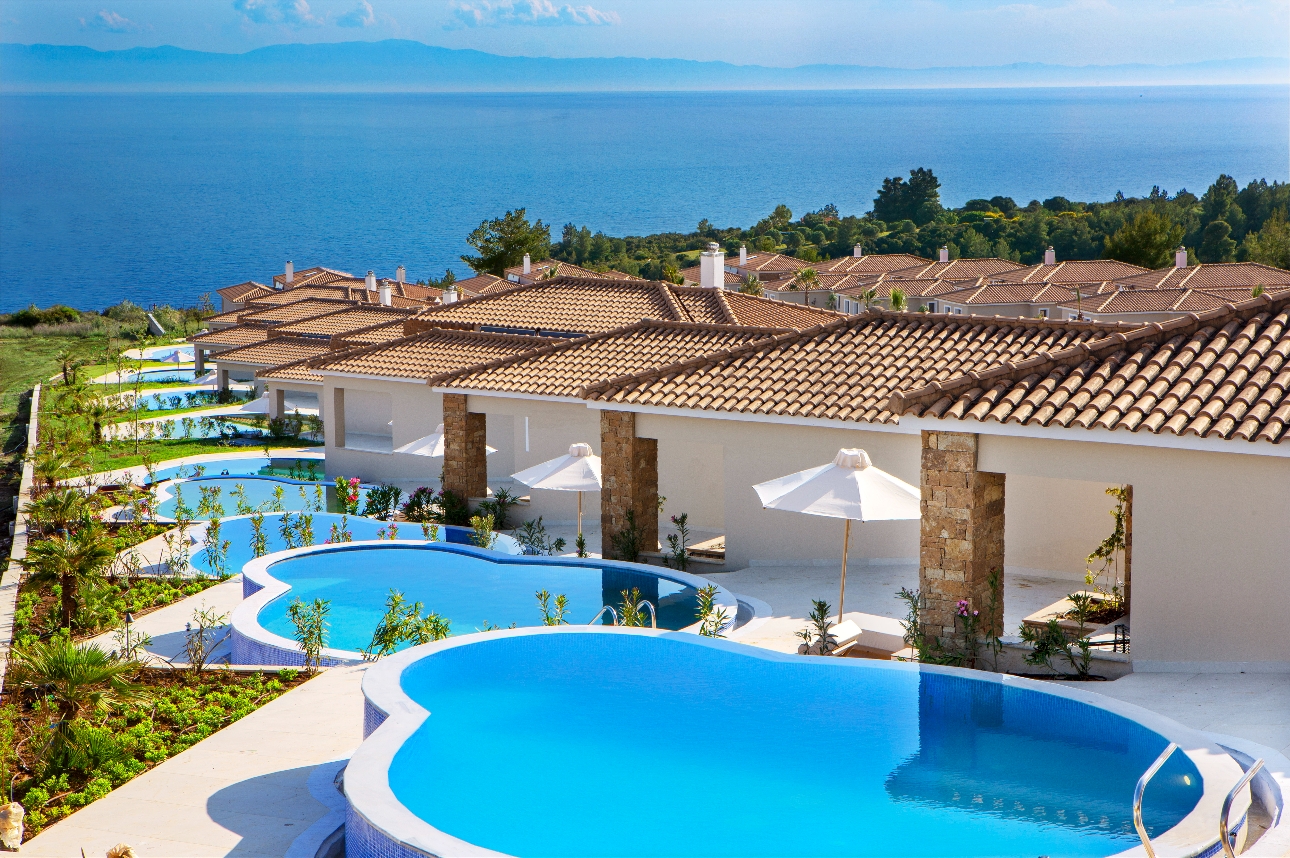 villas with poosl on hillside looking out to sea