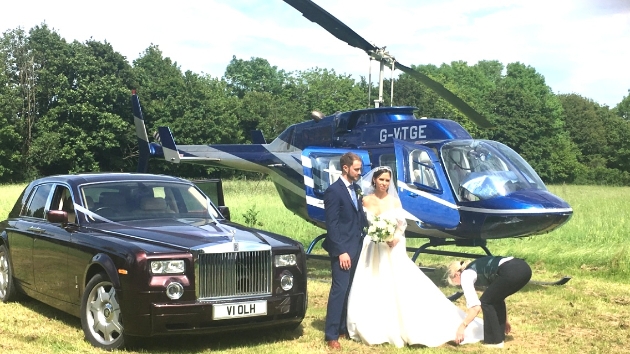 Wedding couple with their rolls royce and helicopter transportation