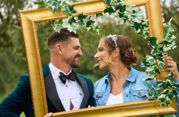 Bride and groom behind a gold frame